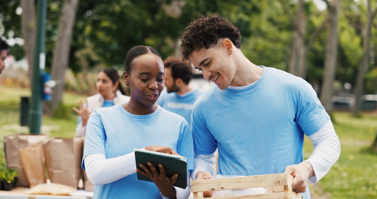 Volunteers working together outdoors during a sober weekend community service project, distributing supplies with a sense of purpose and social responsibility